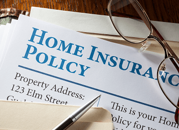paper that reads home insurance policy with a pen and glasses on top