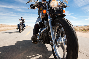 two men driving motorcycles